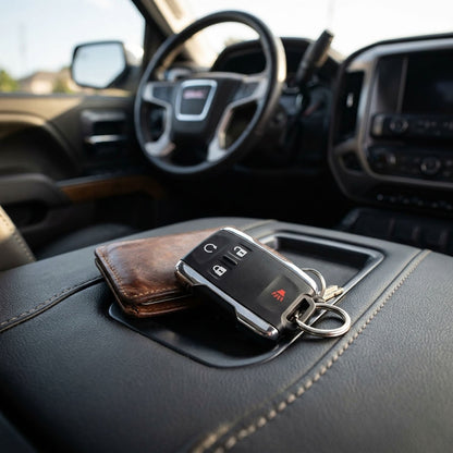 GMC Canyon key fob and brown leather wallet on center console